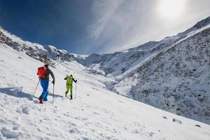 Couple of friends uphill with skis and seal skins photo