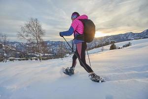 Girl in action with snowshoes during twilight photo