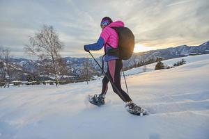 chica en acción con raquetas de nieve durante el crepúsculo foto