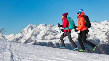 las niñas caminan con crampones en la nieve en las montañas foto