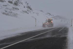 Snowplow in mountain road photo