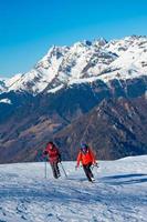 Two female friends during a mountaineering walk in the snow photo