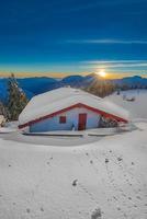 Alpin hut in the snow during sunset photo