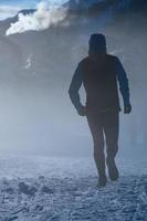 Man runs on the snow in the cold of winter photo