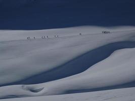 Snow drawings with climbers walking in the distance photo