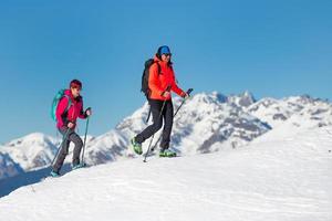 dos amigas montañeras mientras escalan una montaña en invierno foto