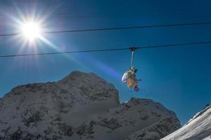 Ski lifts shot against bright sun in mountains photo