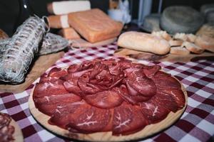 Chopping board of bresaola on a table of local local products photo