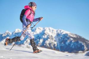 Young sporty woman in the snow with crampons and gaiters photo