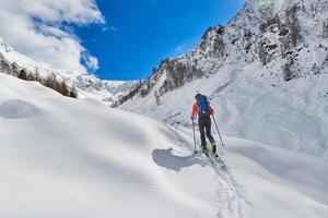 chica hace esquí de montaña cuesta arriba sola foto