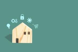 Smart home concept. wooden home with pop up smart icons on green background and copy space. Backdrop for home in the future. photo