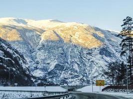 Driving at sunrise through mountains and forests in Norway. photo