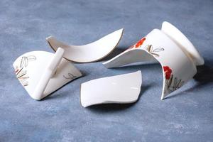 Fragments of white fragile porcelain cup photo