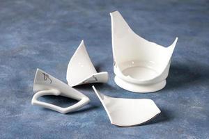 Fragments of white fragile porcelain cup photo