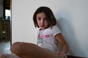 Crying girl sitting on the floor at home. photo
