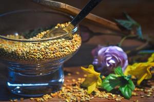 Bee pollen. In a glass container with a spoon photo