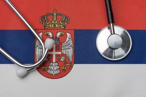 Flag of Serbia and stethoscope. The concept of medicine. photo