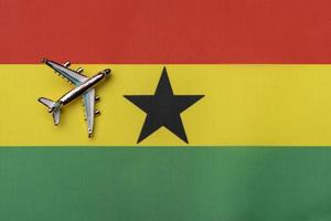 Plane over the flag of Ghana, the concept of journey. photo