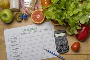 Diet plan, tape measure, water, diet of fresh fruits on the wooden floor. photo