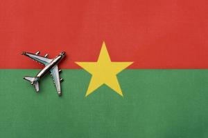 Plane over the flag of Burkina Faso, the concept of travel. photo