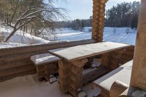 Fresh pure snow covering brown mahogany wood color painted garden chairs and outdoor table. photo