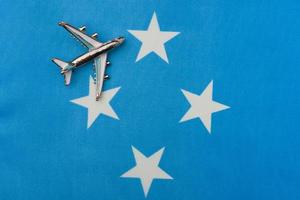 Plane over the flag of Micronesia concept of travel and tourism. photo