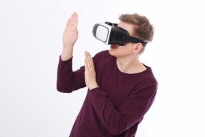 Excited young man in a VR headset, glasses. Virtual reality isolated on white background. Copy space and mock up photo