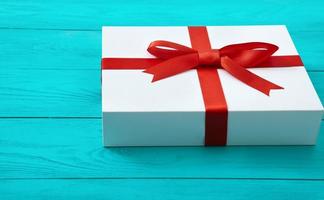 Fashionable gift box on blue wooden background with copy space. Selective focus. photo