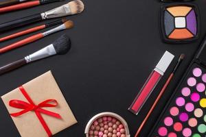 Frame of cosmetics and make up products on black background. Copy space and mock up. Summer fashion photo