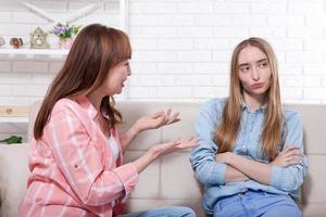 Early pregnancy. Mother and daughter are sitting on sofa at home background. Copy space and mock up photo
