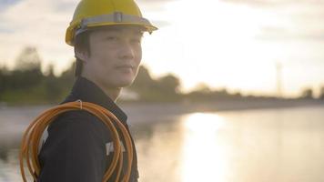 A male engineer wearing a protective helmet at sunset. photo
