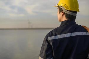 A male engineer wearing a protective helmet at sunset. photo