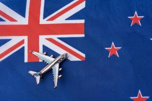 Plane over the flag of New Zealand travel concept. photo