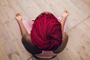 closeup of the red braids of a woman doing meditation