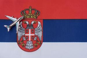 Airplane over the flag of Serbia travel concept. photo