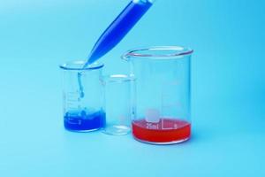A scientist using a pipette analyzes a colored liquid to extract DNA and molecules in a laboratory glass. photo