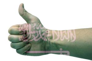 Concept of Saudi Arabia-the hand gives a thumbs up with the flag of Saudi Arabia. photo