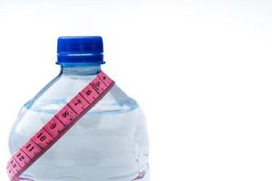 plastic bottle with water and measuring tape isolated on white photo