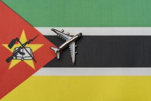 avión sobre la bandera de mozambique, el concepto de viaje. foto