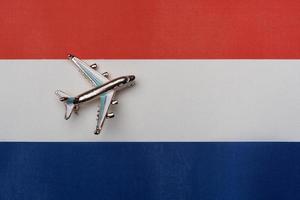 Plane over the flag of the Netherlands, the concept of journey. photo