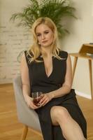 Stylish woman in a black dress with a glass of whiskey. photo