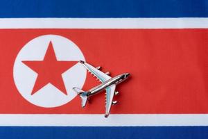 Airplane over North Korea flag travel concept. photo