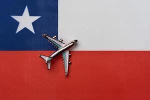 Plane over the flag of Chile, the concept of journey. photo