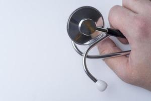 Hand doctor holding a stethoscope on a white background. photo