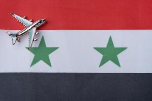 Airplane over Syria flag travel concept. Toy plane. photo