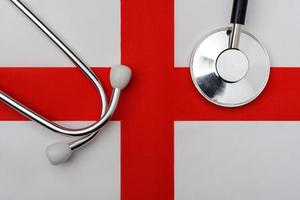 The flag of the English Kingdom and a stethoscope. photo