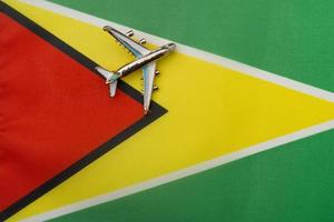 Plane over the flag of Guyana, the concept of travel and tourism. photo