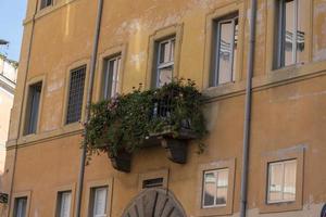 balcón en la ciudad de roma cubierto de flores. foto