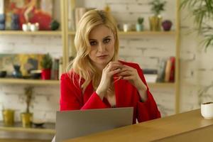 Beautiful blonde business lady working at home on a laptop. photo