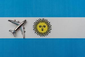 Plane over the flag of Argentina travel concept. photo